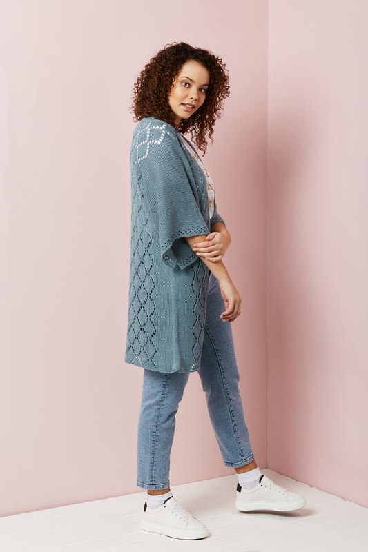 A long cardigan in a faded blue colour is pictured modelled from the side.